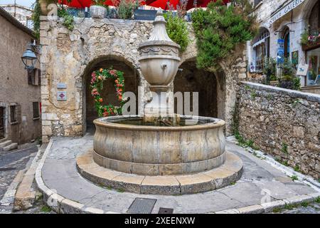 Monumentale fontana in pietra nella cittadina medievale di Saint Paul de Vence, nel dipartimento delle Alpi marittime della Costa Azzurra nel sud della Francia Foto Stock