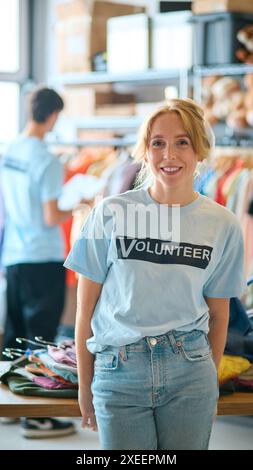 Ritratto di una lavoratrice di beneficenza femminile che ordina le donazioni di abbigliamento al Thrift Store Foto Stock