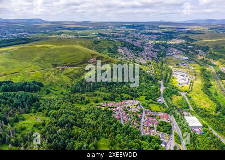 Verdi colline, alberi e un piccolo paese in una profonda valle Foto Stock