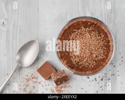 Budino di cioccolato al cioccolato in bicchiere su un tavolo grigio Foto Stock