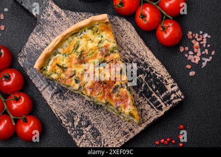 Deliziosa quiche fresca con broccoli, formaggio, spezie ed erbe tagliate a pezzi Foto Stock