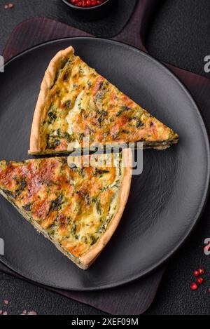 Deliziosa quiche fresca con broccoli, formaggio, spezie ed erbe tagliate a pezzi Foto Stock