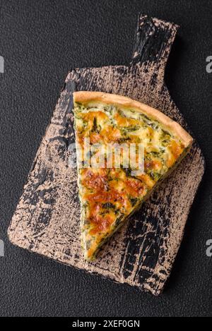 Deliziosa quiche fresca con broccoli, formaggio, spezie ed erbe tagliate a pezzi Foto Stock