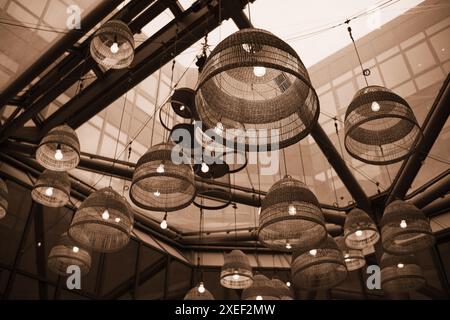 Lampade con sfumature in vimini sotto un soffitto di vetro nel moderno business center o ristorante. Foto Stock