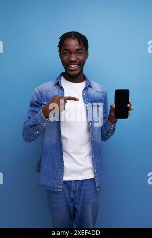 L'elegante uomo americano con dreadlock neri usa lo smartphone Foto Stock