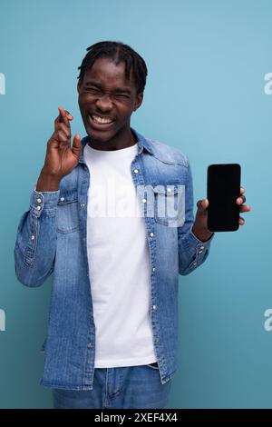 Uomo africano sorridente con dreadlock neri che usano lo smartphone Foto Stock