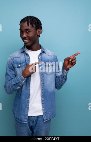 Ritratto ravvicinato di un giovane e intelligente americano con dreadlock in una giacca in denim e un'idea geniale Foto Stock