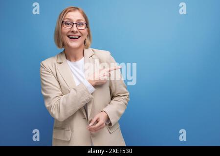 Donna d'affari di mezza età che mostra un gesto della mano su uno sfondo luminoso dello studio con spazio per le copie Foto Stock