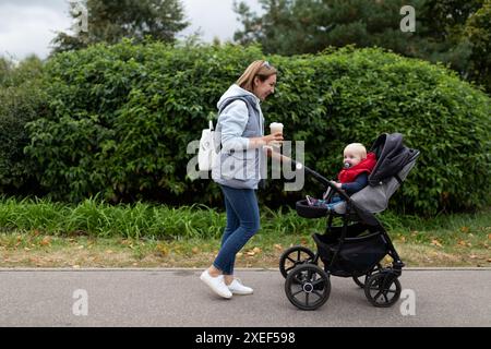 La giovane madre cammina con il suo bambino nel parco Foto Stock