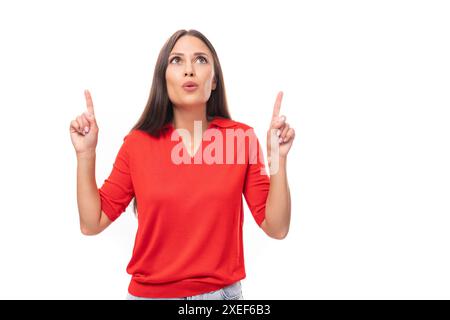 donna caucasica di 30 anni con capelli scuri dritti vestita con una camicia a manica corta rossa mantiene un segreto Foto Stock