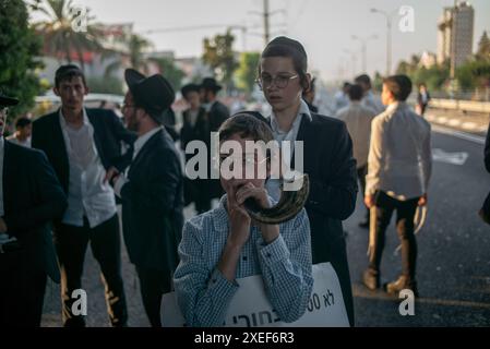 Beni Brak, Israele. 27 giugno 2024. Gli ebrei ultra ortodossi protestano contro il servizio militare obbligatorio in Israele. I nove giudici della Corte Suprema di Gerusalemme hanno stabilito che non esiste alcuna base giuridica per esentare gli ultra-ortodossi dal servizio militare obbligatorio e hanno approvato due petizioni che avevano chiesto la loro immediata coscrizione. Crediti: Ilia Yefimovich/dpa/Alamy Live News Foto Stock