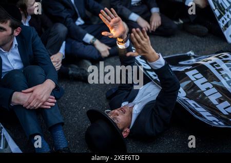 Beni Brak, Israele. 27 giugno 2024. Gli ebrei ultra ortodossi protestano contro il servizio militare obbligatorio in Israele. I nove giudici della Corte Suprema di Gerusalemme hanno stabilito che non esiste alcuna base giuridica per esentare gli ultra-ortodossi dal servizio militare obbligatorio e hanno approvato due petizioni che avevano chiesto la loro immediata coscrizione. Crediti: Ilia Yefimovich/dpa/Alamy Live News Foto Stock