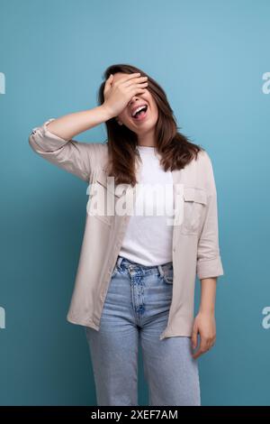 Sorridente donna bruna caucasica in camicia e jeans Foto Stock
