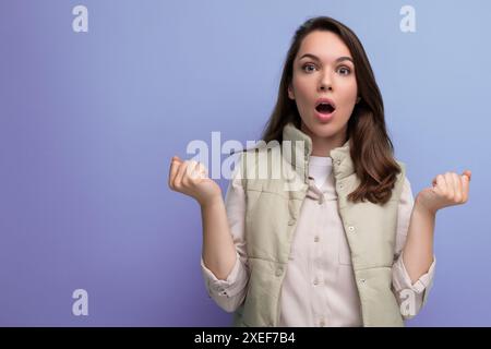 Scioccata giovane donna bruna caucasica in abiti casual con bocca aperta sullo sfondo dello studio Foto Stock