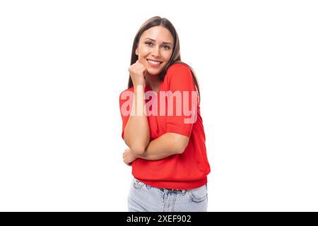 La bella donna caucasica con i capelli neri indossa una blusa rossa con scollo a V su sfondo bianco e spazio per le copie Foto Stock