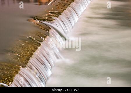 l'acqua scorre dalla soglia sul fiume, movimento sfocato dell'acqua Foto Stock