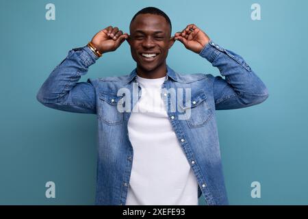 Bello, confuso, giovane e attraente uomo africano vestito casualmente in denim Foto Stock