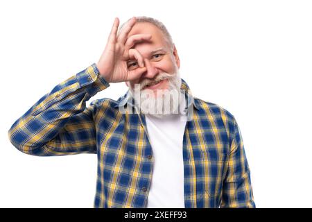 Affascinante pensionato anziano dai capelli grigi e ben curato con barba in camicia Foto Stock