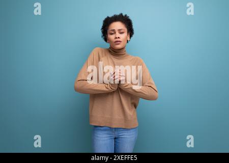 Giovane donna latina, graziosa e coccolata, con capelli ricci sullo sfondo e spazio per le copie Foto Stock