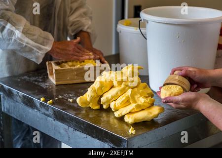 Il burro alpino giallo dorato viene porzionato utilizzando una tradizionale muffa di legno. Produzione di burro nel caseificio appartenente al Filzmoosalm. Promegg, Großarl, Salisburgo, Austria Foto Stock