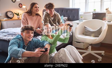 Gruppo di adolescenti e ragazzi a casa in camera da letto insieme che giocano a giochi per computer insieme Foto Stock