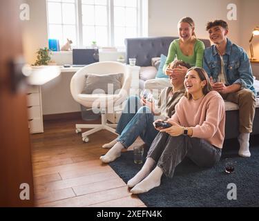 Gruppo di adolescenti e ragazzi a casa in camera da letto insieme che giocano a giochi per computer insieme Foto Stock