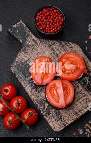 Deliziose melanzane tagliate in cerchio alla griglia e cotte con maionese e pomodori Foto Stock