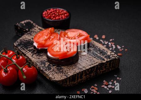 Deliziose melanzane tagliate in cerchio alla griglia e cotte con maionese e pomodori Foto Stock