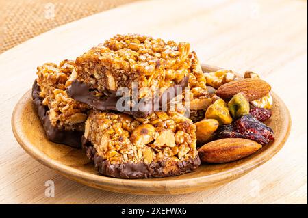 Vista ad alto angolo delle croccanti arachidi fatte in casa, mandorle e barrette di cioccolato. Foto Stock