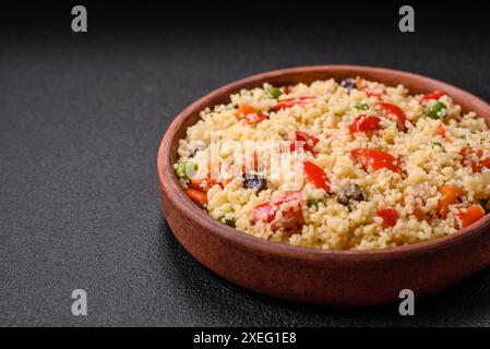 Delizioso porridge di couscous con cubetti di verdure grigliate con sale e spezie Foto Stock