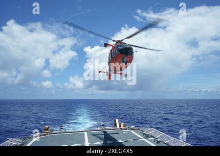 Un elicottero MH-65 Dolphin imbarcato Coast Guard Helicopter Interdiction Tactical Squadron conduce operazioni di volo dalla Guardia Costiera Cutter Stone, (WMSL 758), 22 giugno 2024, mentre era in corso nell'Oceano Atlantico. Stone opera nell'Oceano Atlantico a sostegno della stabilità e della sicurezza marittima nella regione. (Foto della Guardia Costiera degli Stati Uniti di Joanna Burzo, sottufficiale di terza classe) Foto Stock