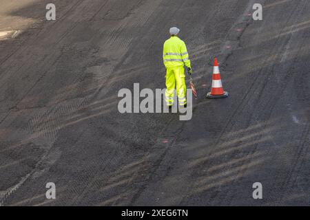 Vista ad angolo elevato di un operaio edile che lavora su una ristrutturazione stradale Foto Stock