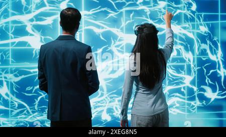 Gli ingegneri utilizzano il visore VR e le reti neurali ai modellate sul cervello umano per risolvere problemi complessi. Esperti IT che utilizzano l'intelligenza artificiale e la tecnologia della realtà virtuale per esaminare i dati, telecamera A. Foto Stock