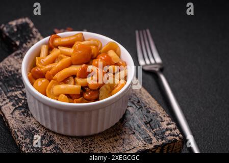 Deliziosi funghi al miele sottaceto con sale e spezie in un piatto di ceramica Foto Stock