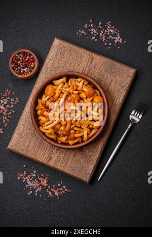 Deliziosi funghi al miele sottaceto con sale e spezie in un piatto di ceramica Foto Stock