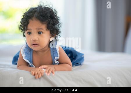 Bambino che gioca felicemente con i giocattoli sul letto in una camera da letto di casa Foto Stock