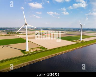 Un'affascinante vista aerea di un parco eolico a Flevoland, nei Paesi Bassi, dove torreggianti mulini a vento si stagliano con grazia nel vento, nel genere Foto Stock