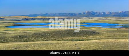 panorama del lago di roccia spaccata sulla prateria sotto il fronte roccioso della montagna vicino a choteau, montana Foto Stock