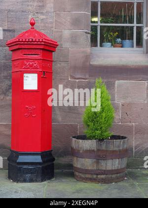 Tradizionale posta ottagonale inglese vittoriana in ghisa rossa brillante o cassetta postale Foto Stock