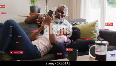 Immagine di icone dei social media e reti su uomo e donna afroamericani con telefono Foto Stock