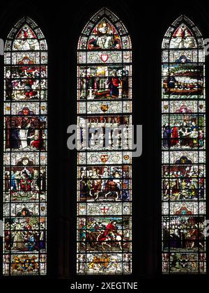 Vetrata a ovest che mostra scene della storia della chiesa di San Giovanni Battista a Chester. Creato da EDW Foto Stock