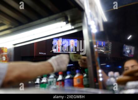 New York, Stati Uniti. 27 giugno 2024. Il dibattito presidenziale della CNN tra il presidente Joe Biden e l'ex presidente Donald Trump è visto attraverso un carrello di venditori a Times Square di New York giovedì 27 giugno 2024. Il dibattito si svolge negli studi di Atlanta della CNN con Jake Tapper e Dana Bash come moderatori. Foto di John Angelillo/UPI credito: UPI/Alamy Live News Foto Stock