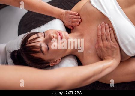 Primo piano del ritratto di una giovane bella donna che riceve un massaggio al collo e alle spalle. Foto Stock