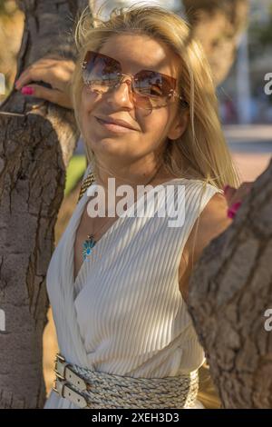 Questa immagine raffigura una bella donna bionda con capelli lunghi e dallo stile professionale. Foto Stock