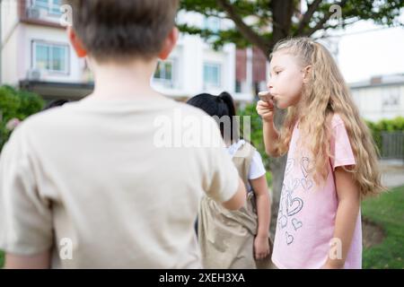 Scolari che partecipano ad attività all'aperto e si rilassano mangiando un gelato. Foto Stock