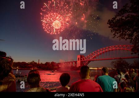 New York, Stati Uniti. 27 giugno 2024. NEW YORK, NEW YORK - GIUGNO 27: Gli spettatori guardano i fuochi d'artificio esplodere durante le celebrazioni annuali del giorno dell'indipendenza di Central Astoria esibiscono fuochi d'artificio nell'Astoria Park il 27 giugno 2024 nel quartiere Queens di New York City. Crediti: Ron Adar/Alamy Live News Foto Stock