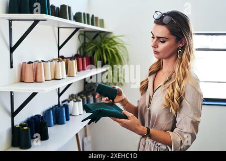 Tessuto, colore e donna con confronto di fili presso lo studio di design per moda, abbigliamento o startup di piccole imprese. Creativa, industriale e sarta femminile Foto Stock