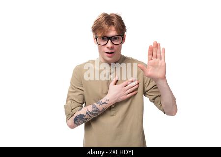 Giovane e bellissimo ragazzo caucasico con i capelli rossi in una camicia marrone Foto Stock