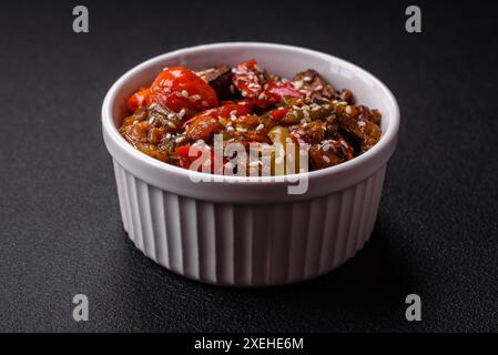 Insalata calda con vitello, pomodori, peperoni, zucchine, sesamo, sale, spezie ed erbe aromatiche Foto Stock