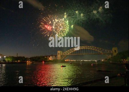 New York, Stati Uniti. 27 giugno 2024. I fuochi d'artificio esplodono sul ponte Hell Gate durante le celebrazioni annuali del giorno dell'indipendenza di Central Astoria, nel parco Astoria, nel quartiere Queens di New York City. Credito: SOPA Images Limited/Alamy Live News Foto Stock